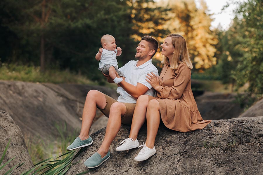 Junge Familie mit Baby sitzt in der Natur