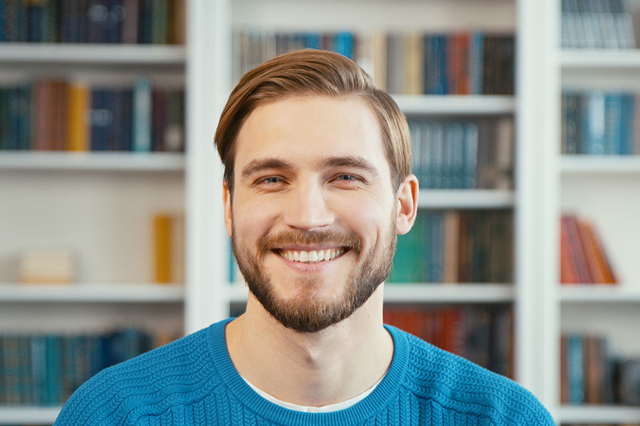 Junger Mann lächelt in die Kamera